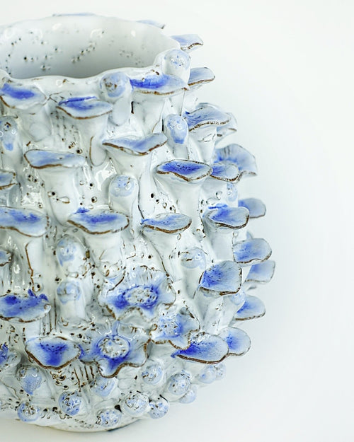 Decorative ceramic vase with blue floral patterns on a white background