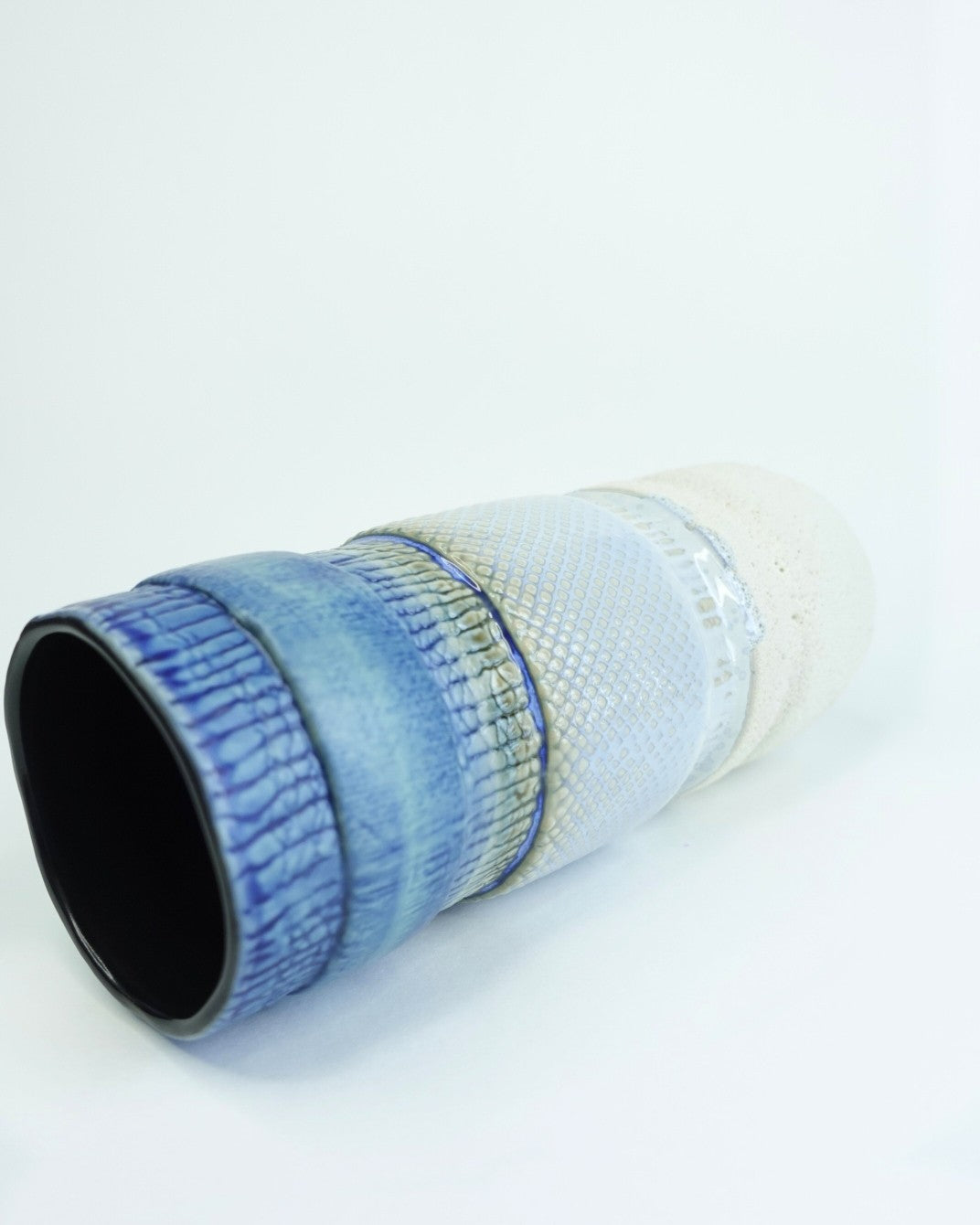 Ceramic cup with blue and white design on a white background