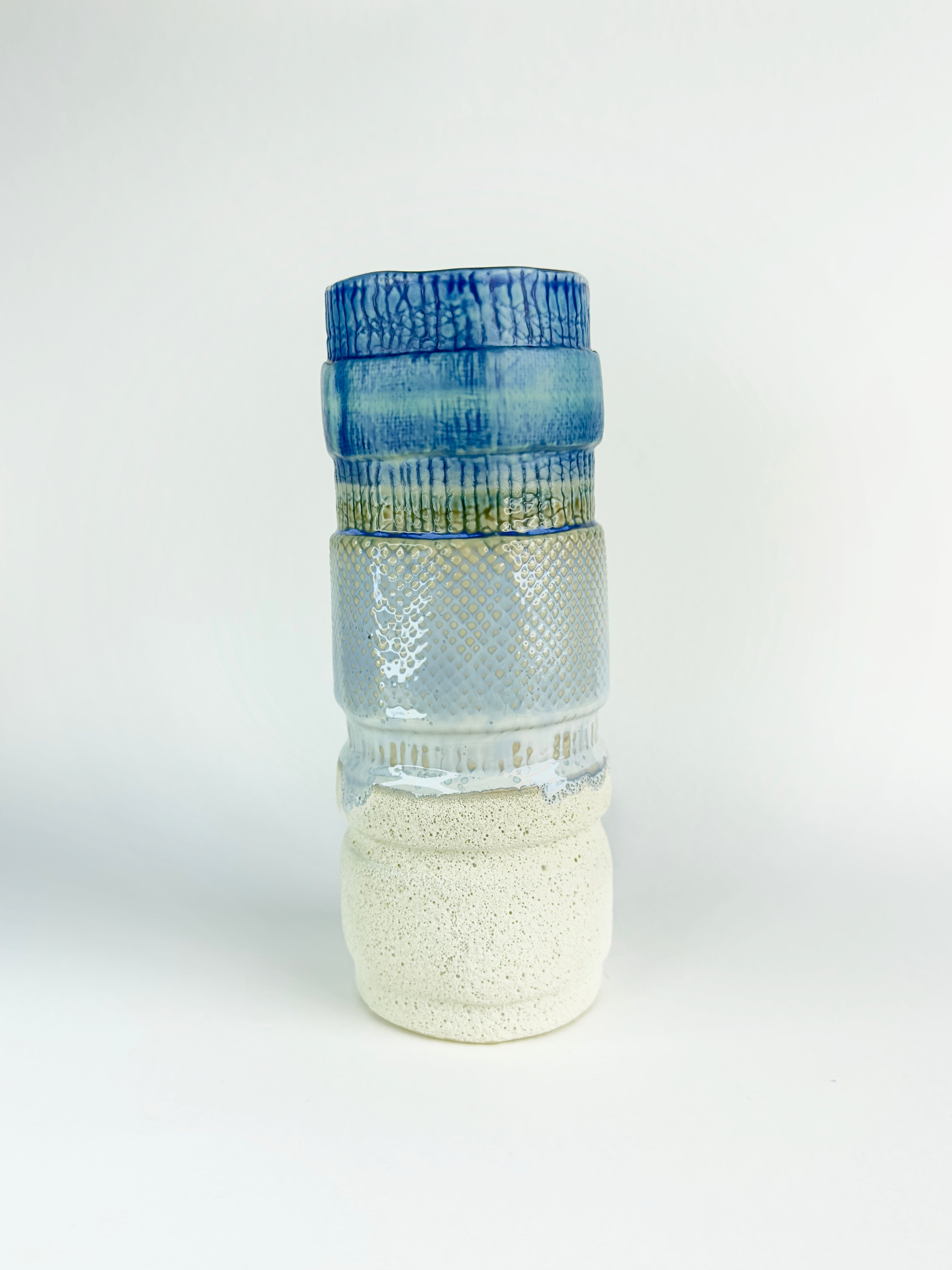 Decorative glass bottle with textured design on a white background